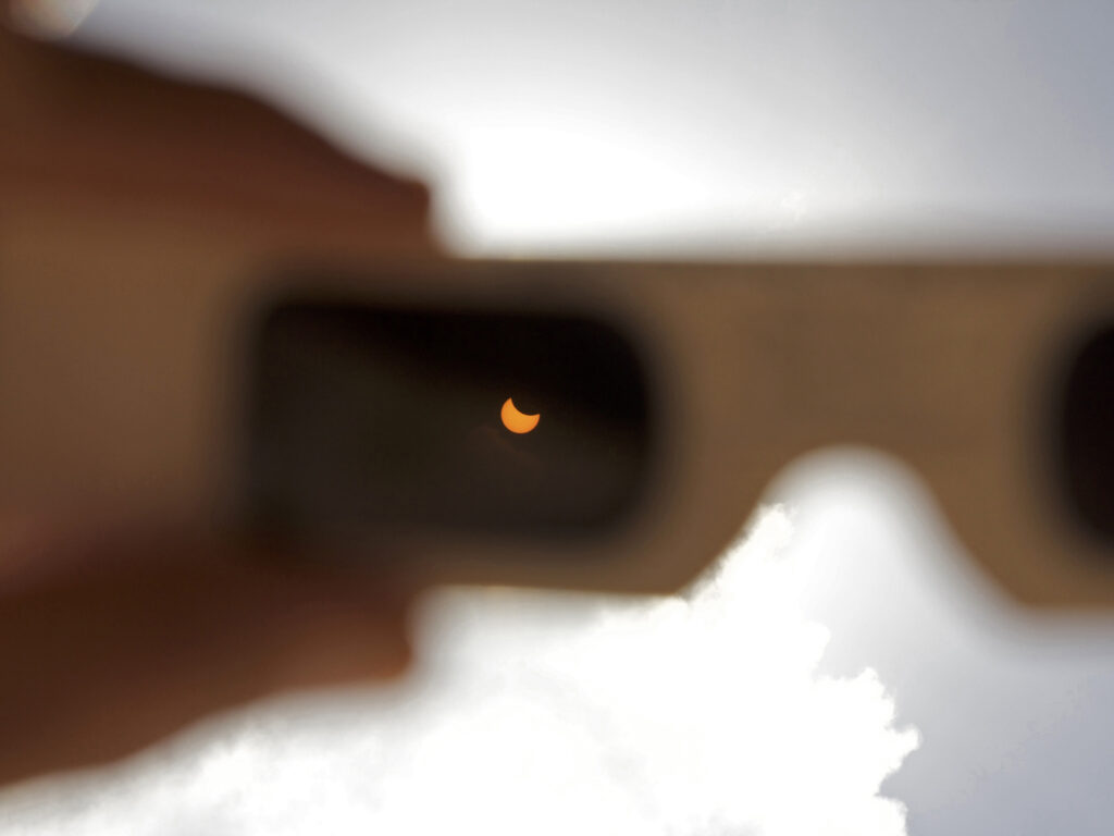 Partial solar eclipse viewed through eclipse glasses