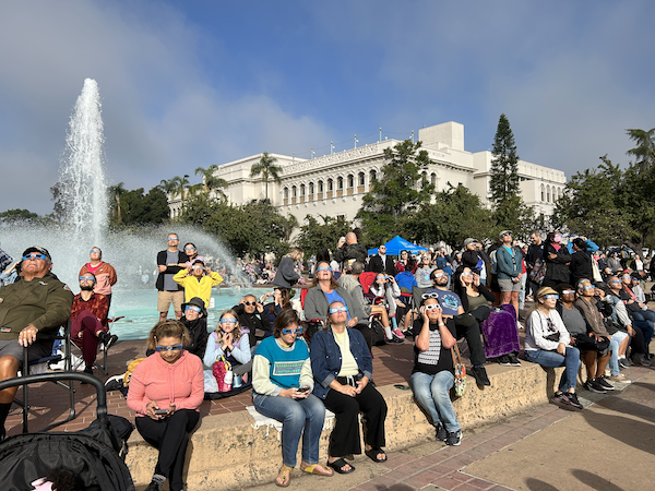 Crowds outside observing a solar eclipse safely!